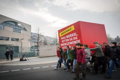 Greenpeace Aktivisten protestieren mit einem überdimensional großen Würfel vor dem Bundeskanzleramt, 01.04.2014