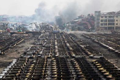 Ausgebrannte Autos, dahinter Häuser, die die Explosionen ebenfalls zerstörten.