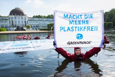 Aktivist mit Banner "Macht die Meere plastikfrei"