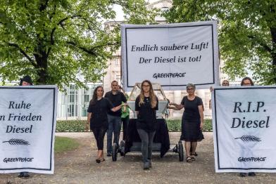 Greenpeace-Aktivisten tragen einen Dieselmotor in einem Sarg und fordern das Aus für den Diesel.