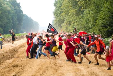 Demonstranten in rot bilden am Hambacher Forst eine Linie