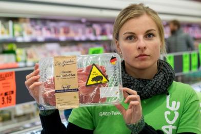 Greenpeace-Aktivistin mit umetikettiertem Billigfleisch von Lidl