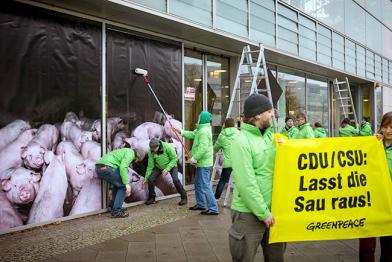 Aktivisten bekleben in Berlin die CDU-Parteizentrale mit Fotofolien mit Schweinestall-Motiv