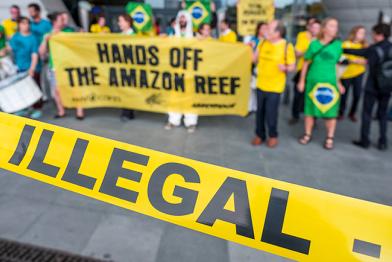 Greenpeace-Aktivisten protestieren in Paris gegen Öl, Absperrband mit Aufschrift "Illegal"