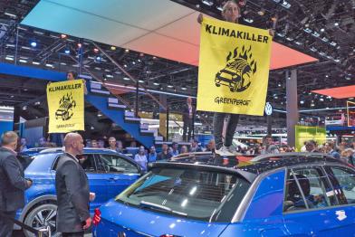 Greenpeace-Aktivisten mit Banner "Klimakiller" auf SUV auf IAA
