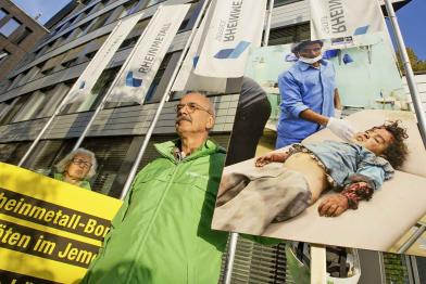 Stoppt deutsche Waffen im Jemenkrieg: Aktivisten halten Banner und Fotos von verletzten Kindern vor der Firmenzentrale von Rheinmetall