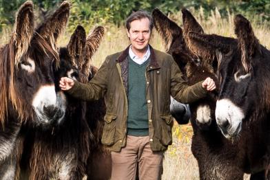 Kai Frölich, Direktor der Arche Warder umringt von Poitou-Eseln