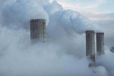 Rauchende Schornsteine eines Kohlekraftwerks in Fimmersdorf, März 1995