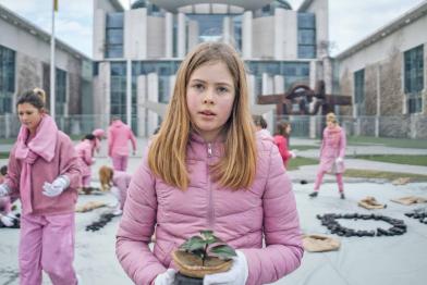 Mädchen in Rosa mit Bäumchen vor Kanzleramt in Berlin