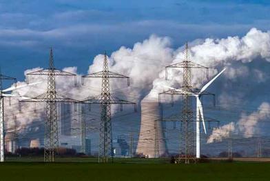 Braunkohlekraftwerk Neurath bei Grevenbroich - Dampf steigt aus Kühltürmen auf, im Vordergrund Windräder.