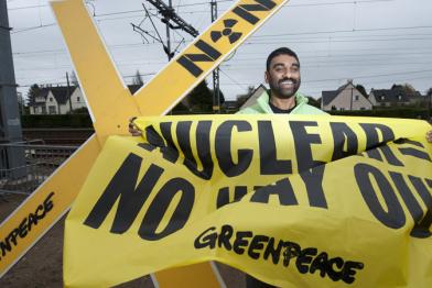 Kumi Naidoo mit Protestbanner in Valognes 11/05/2010