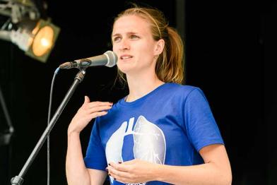Marion Tiemann von Greenpeace spricht bei der Fahrradsternfahrt in Köln. Die Lunge auf ihrem T-Shirt symbolisiert die Gefahr durch Dieselfahrzeuge, die gesundheitsschädliche Stickoxide ausstoßen.
