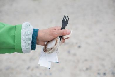 Greenpeace-Aktivistin hält einen Plastikgabel in die Kamera. Gefunden wurde sie bei einer Aufräumaktion am Strand von Helgoland