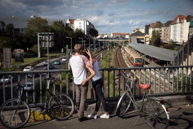 Junger Mann und junge Frau auf Brücke schauen auf den Verkehr unter ihnen