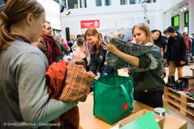 Junge Menschen begutachten gebrauchte Kleidung bei Greenpeace Make Something-Event in Hamburg