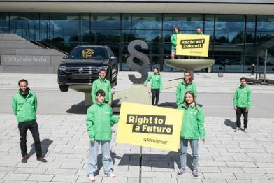 Young activists from Greenpeace demonstrate with an oversized scale, before Volkswagen's General Meeting.