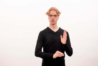 Blonder junger Mann mit Brille spricht Gebärdensprache
