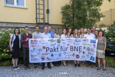 Menschengruppe mit Banner "Pakt für BNE"