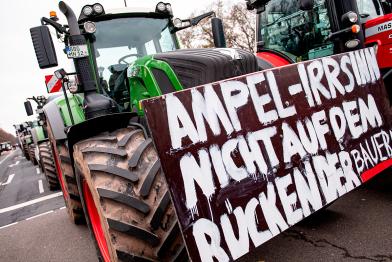 Traktor mit Schild auf der Straße: "Ampel-Irrsinn nicht auf dem Rücken der Bauern".