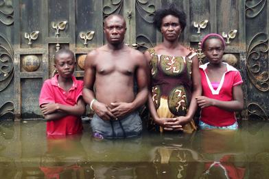 Familie in Negeria in einer überfluteten Straße