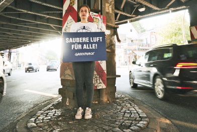 Greenpeace-Aktivistin mit einem Schild "Saubere Luft für alle an der Stresemannstraße in Hamburg. Dort ist das Diesel-Fahrverbot ab heute inkraft.