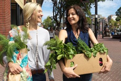 Zwei Frauen tragen frisches Gemüse