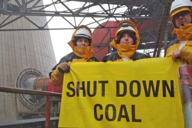 Aktivisten mit Banner vor Kohlekraftwerk Neurath