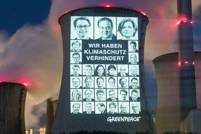 Projektion auf Kühlturm des Braunkohlekraftwerks Neurath: 31 Portraits der schlimmsten Klimabremser aus Union und SPD sowie den Schriftzug "Wir haben Klimaschutz verhindert".