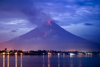 2006: Der philippinische Vulkan Mayon bricht aus. Rauch und Asche gehen über der Stadt Legazpi nieder.