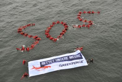50 Greenpeace-Aktivisten geben den Meeren und den Schweinswalen eine Stimme: SOS - der Seenotruf.