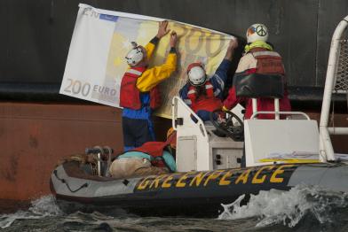 Greenpeace-Aktivisten befestigen falsche Banknoten an dem Trawler Maartje Theadora. Die Fanglizenzen für solche Schiffe werden zu 90 % aus EU-Steuergeldern finanziert.