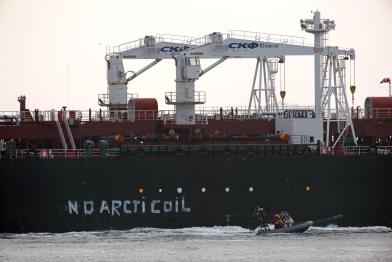 Greenpeace-Aktivisten schreiben an die Bordwand der Mikhail Ulyanov "No Arctic Oil".