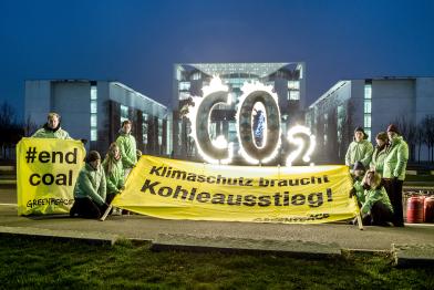 Greenpeace-Aktivisten mit Bannern und brennendem CO2-Schriftzug vor dem Kanzleramt