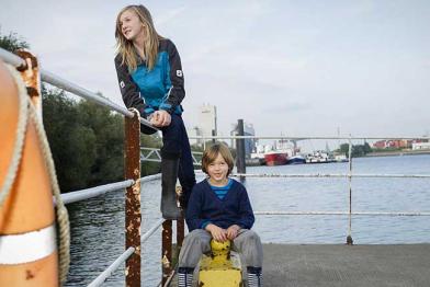 Kinder in Outdoor-Kleidung am Hafen in Hamburg.