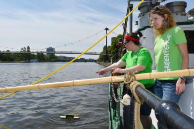 Aktivisten an Bord der Beluga bei der Wasserprobenentnahme