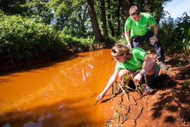 Greenpeace-Aktivisten nehmen Proben von verockertem Spreewasser.