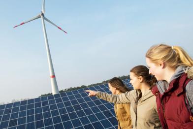 Jugendliche betrachten Solar- und Windkraftanlagen