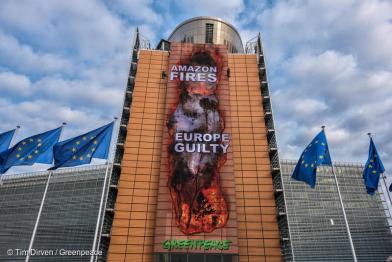 Ein Banner des brennenden Amazonaswald wird an der Außenwand des Gebäudes der EU-Kommission von Aktiven befestigt