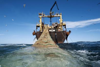 Ein Fabrikschiff mit Schleppnetz vor blauem Himmel