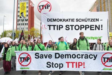 Greenpeace-Aktivisten auf der Anti-TTIP-Demo in Hannover. Sie halten ein Banner mit der Aufschrift "Save Democracy - Stop TTIP".