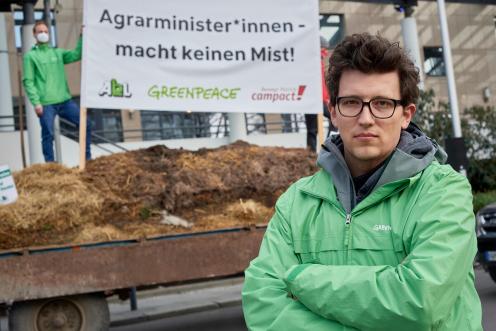 Protest mit Trecker und Hänger vor Agrarminister-Konferenz. Auf dem Banner steht: Agrarminister:innen macht keinen Mist.