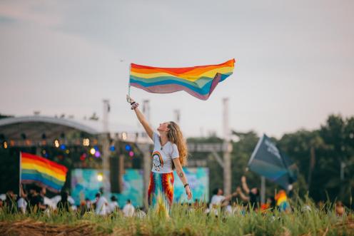 Frau schwenkt eine Regenbogen-Flagge beim Pride March auf den Philippinen
