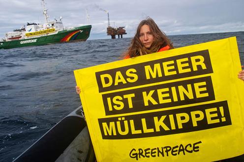 Eine Greenpeace-Aktivistin hält ein Banner mit der Aufschrift "DAS MEER IST KEINE MÜLLKIPPE" bei einer Demonstration gegen Shell im Brent-Feld.