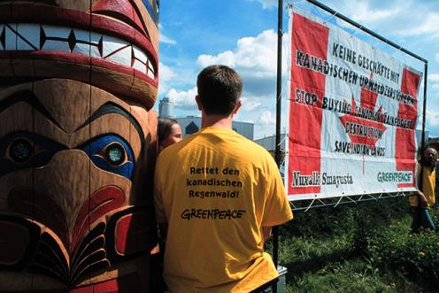 Deutsche Greenpeace-Aktivisten mit Totempfahl