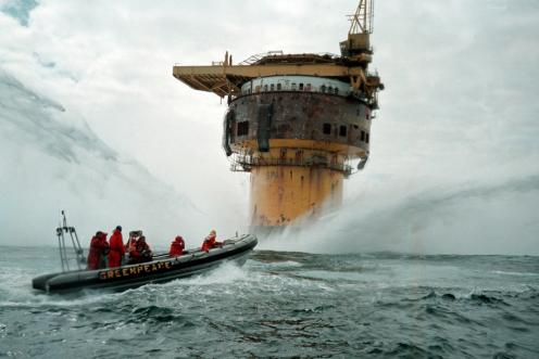 Aktivisten in einem Greenpeace-Schlauchboot steuern auf eine Bohrinsel zu.