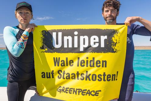 Meeresbiologin Franziska Saalmann und Videographer Micheal Lutman halten Banner gegen Uniper in Schlauchboot im Ningaloo Reef