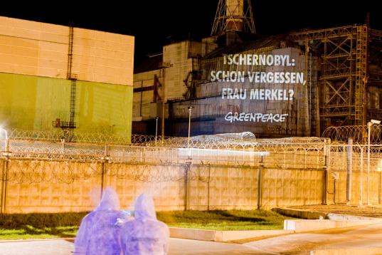 Greenpeace Aktivist:innen projizieren Anti-Atomkraft-Botschaften auf den Sarkophag des Kernkraftwerks Tschornobyl.