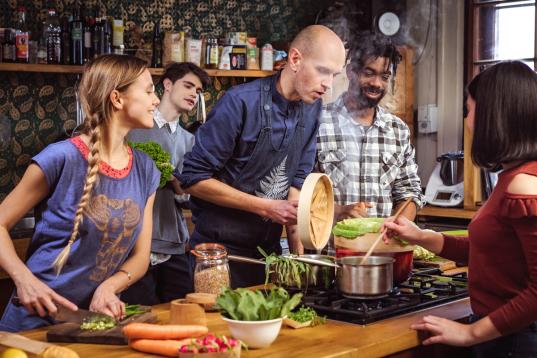 Junge Erwachsene bereiten gemeinsam mit dem Meister der veganen Küche Domen Kavcic vegetarische Gerichte zu.