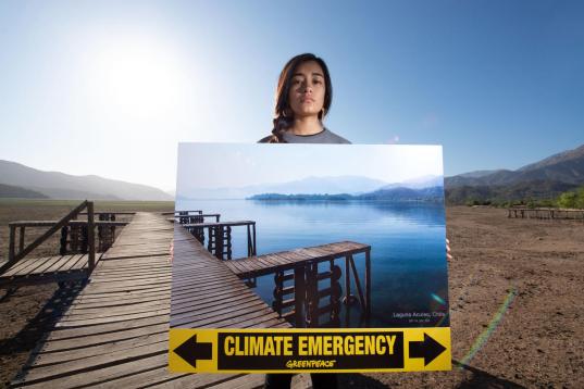 Aktivist:innen protestieren an ausgetrocknetem See für mehr Klimaschutz