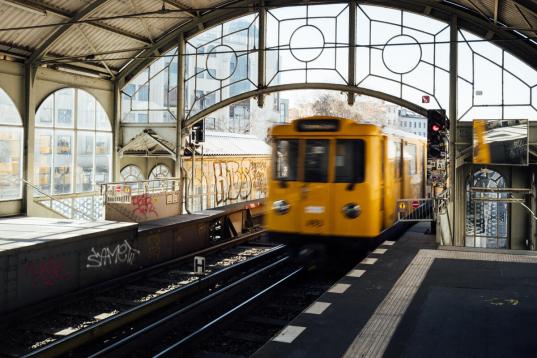 Gelber Zug fährt in einen Bahnhof